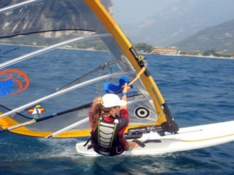 Practicando windsurf en un hermoso día de verano con vistas a la costa.