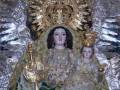 Imagen de una Virgen con un niño en sus brazos, vestida con trajes ornamentados y coronada con una gran corona de estrellas.