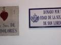 Dos placas informativas sobre Ntra. Sra. de los Dolores y la donación por la Hdad. de la Soledad de San Lorenzo, con detalles sobre su origen y donación.