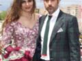 Una pareja posa con elegancia en un evento al aire libre, ella en un vestido floral y él en un traje de tartán verde.
