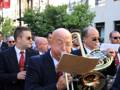 Músicos tocando trombón en una procesión o desfile.