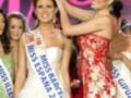 Miss España 2011 en un evento de belleza, con un vestido blanco y una corona en la cabeza, rodeada por otras participantes.