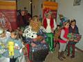 Fiesta de carnaval con niños y adultos disfrazados, celebrando con alegría y regalos.