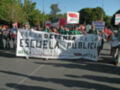 Manifestantes con pancartas en defensa de la escuela pública.