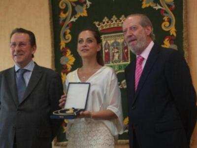 María león muy junto a su madre recoge la medalla de Sevilla para su hermano Paco León