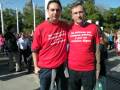 Dos hombres con camisetas rojas en una manifestación. Texto en español sobre derechos laborales y empleo digno.
