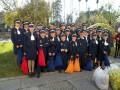 Una escuela de uniforme posando para una foto en un parque con árboles y una palmera en el fondo.