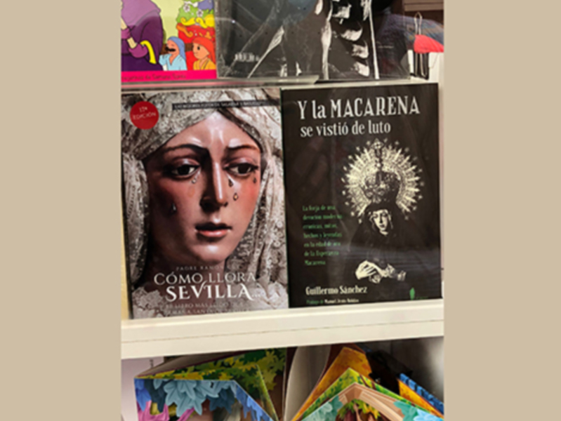 Libros sobre la Macarena y Sevilla en una estantería.