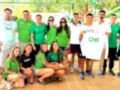 Equipo de voluntarios en una actividad deportiva, con camisetas verdes y un miembro del equipo con una camiseta blanca que dice "CNS".