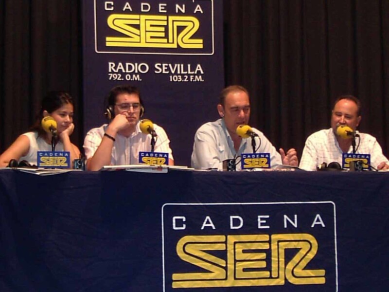 Cuatro personas sentadas en una mesa con micrófonos, frente a un cartel de Cadena SER Radio Sevilla.