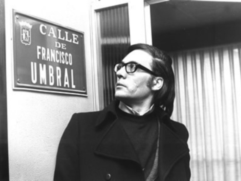 Francisco Umbral, poeta y escritor español, posando frente a una calle con su nombre.
