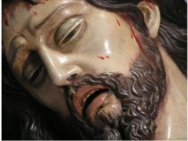 Escultura de Cristo con rasgos dolorosos y sangre en la frente.