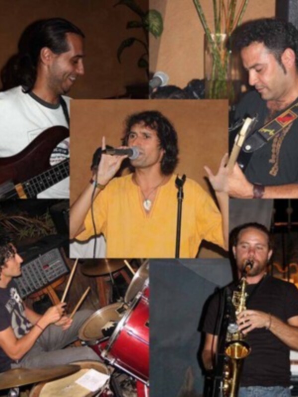Un grupo musical en un concierto, con guitarristas y un saxofonista.