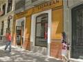 Tienda 'Lizarran' en una calle con gente caminando, destacando su fachada clásica y productos visibles en la ventana.