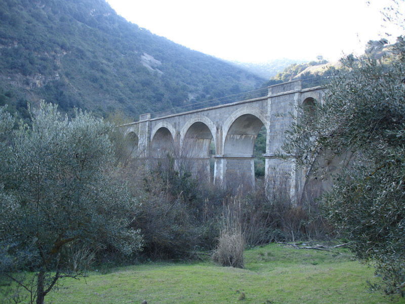 Vigilantón Viaduct in Spain, a historic railway bridge surrounded by lush greenery and hills.
