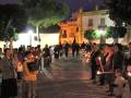 Celebración nocturna con velas en una plaza histórica.