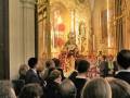 Una multitud en una iglesia, con un altar dorado y estatuas religiosas.