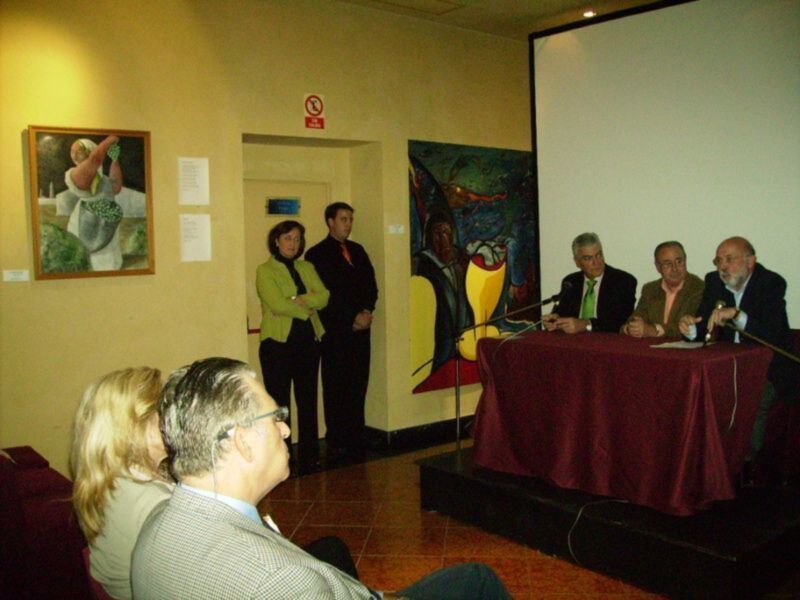 Exposición de arte con panelistas en un evento cultural.