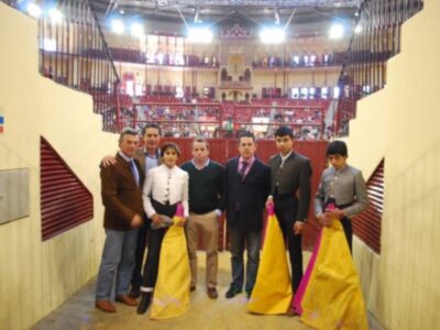 Grupo de personas posando en un estadio deportivo con vestimentas tradicionales.