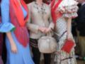 Tres mujeres vestidas con trajes de flamenca posan para la foto en un ambiente festivo. La imagen muestra detalles como vestidos coloridos, joyería y sombrillas típicas de la cultura flamenca.