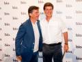 Dos hombres sonrientes posan frente a un fondo con el logo "bio".
