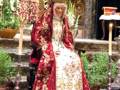 Imaginación de una figura vestida con trajes tradicionales, posiblemente en un evento cultural o religioso, con detalles de ropa y accesorios que sugieren un estilo histórico o ceremonial.