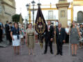 Celebración religiosa con portadores de estandartes y procesión en una plaza histórica.