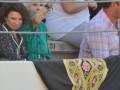 Una persona con un traje de piel y gafas de sol, otra con una camisa verde y pantalones blancos, y un hombre en una camiseta a cuadros.