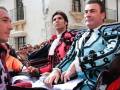 Hombre vestido con traje de luces en un desfile o evento público.