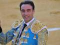 Un torero en su traje tradicional, sonriendo y posando para la foto.