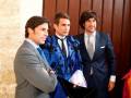 Tres hombres en trajes diferentes, uno con chaqueta azul y corbata negra, otro con chaleco azul y corbata blanca, el tercero con traje azul y corbata gris.
