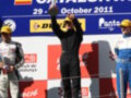 Triunfo en el European F3 Open 2011, con el ganador celebrando en el podio y el segundo lugar observando.