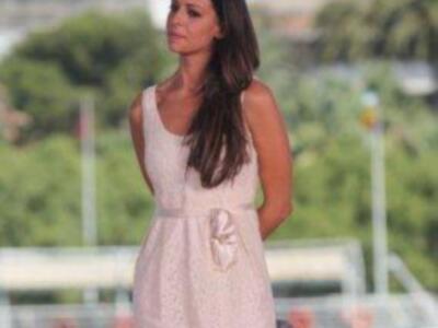 Una mujer con vestido rosa en la playa.