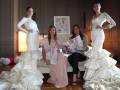 Tres modelos posan con vestidos de novia en una presentación de moda.