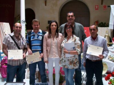 Una foto de un grupo de personas posando con sus premios, en un ambiente festivo.