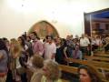 Asistentes en una iglesia durante una ceremonia o evento religioso.