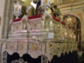 Interior de una iglesia con altares ornamentados y estatuas religiosas.