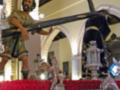 Escultura religiosa de un santo en una iglesia, con detalles dorados y rojos.