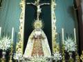 Imagen de una Virgen María en un altar dorado, con un Cristo crucificado y velas encendidas.
