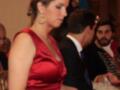 Una mujer en un vestido rojo con una trenza en el cabello, posiblemente en un evento formal.