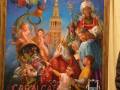 Un cuadro con personajes de la Cabalgata de Reyes Magos en Sevilla 2013, incluyendo ángeles, reyes y un personaje con un sombrero de plumas, con la Giralda de Sevilla al fondo.