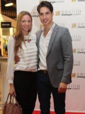 Dos personas posan en un evento con el logo de Sevilla thestyle outlets visible.