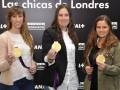 Tres mujeres sostienen medallas de oro en una celebración de logros deportivos.