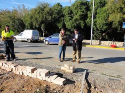Trabajadores y autoridades inspeccionan obras de construcción en una calle urbana.