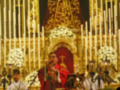 Procesión religiosa con la Virgen de la Candelaria en un altar ornado con velas y flores.