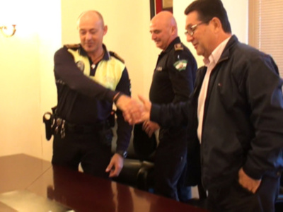 Un oficial de policía y un hombre civil se saludan en una reunión formal.