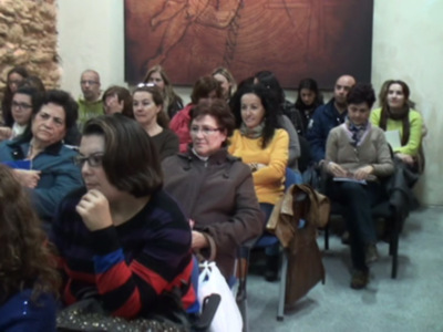 Auditorio lleno de personas escuchando una charla o presentación en un ambiente académico o cultural.
