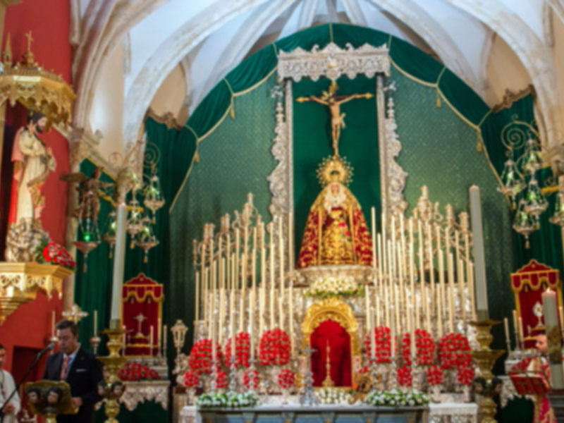Imagen de una iglesia con altares ornamentados, estatuas religiosas y candelabros.