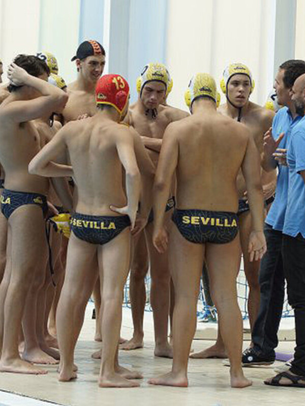 Equipo de waterpolo masculino de Sevilla durante una reunión técnica en la piscina.