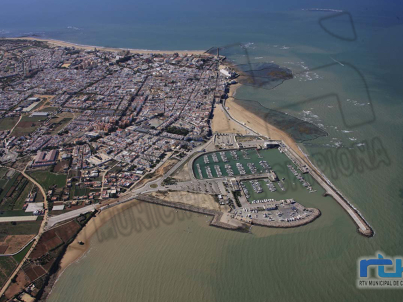 Aerial view of a coastal city with a marina and beach.